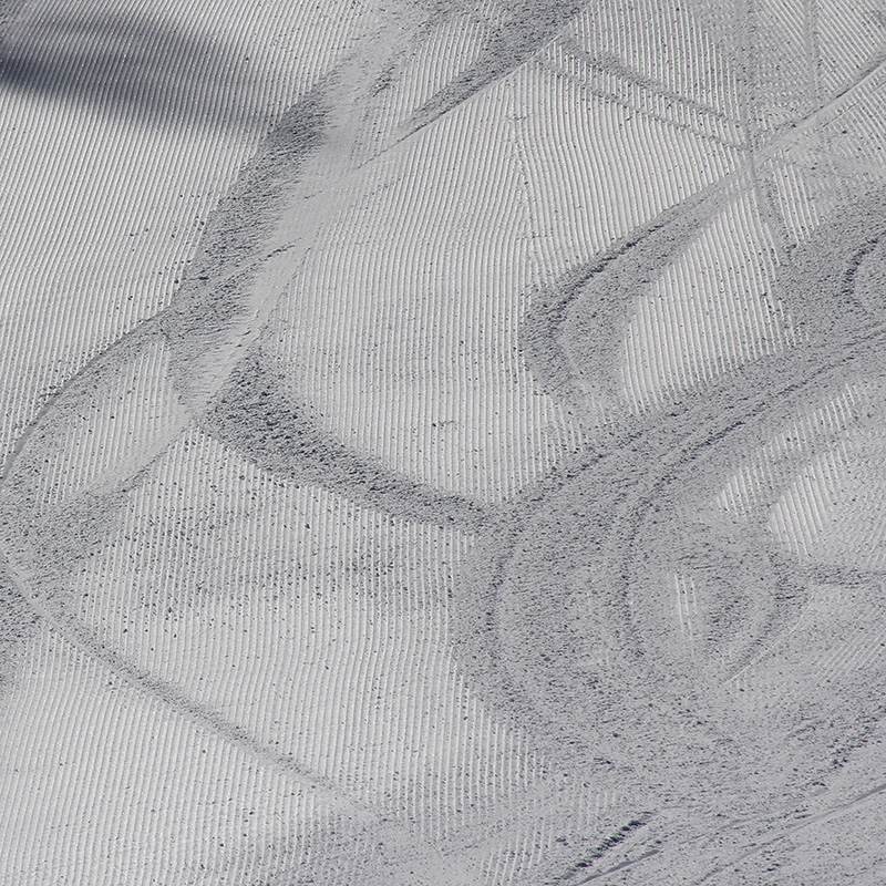 Ski and snowboard tracks over freshly groomed snow