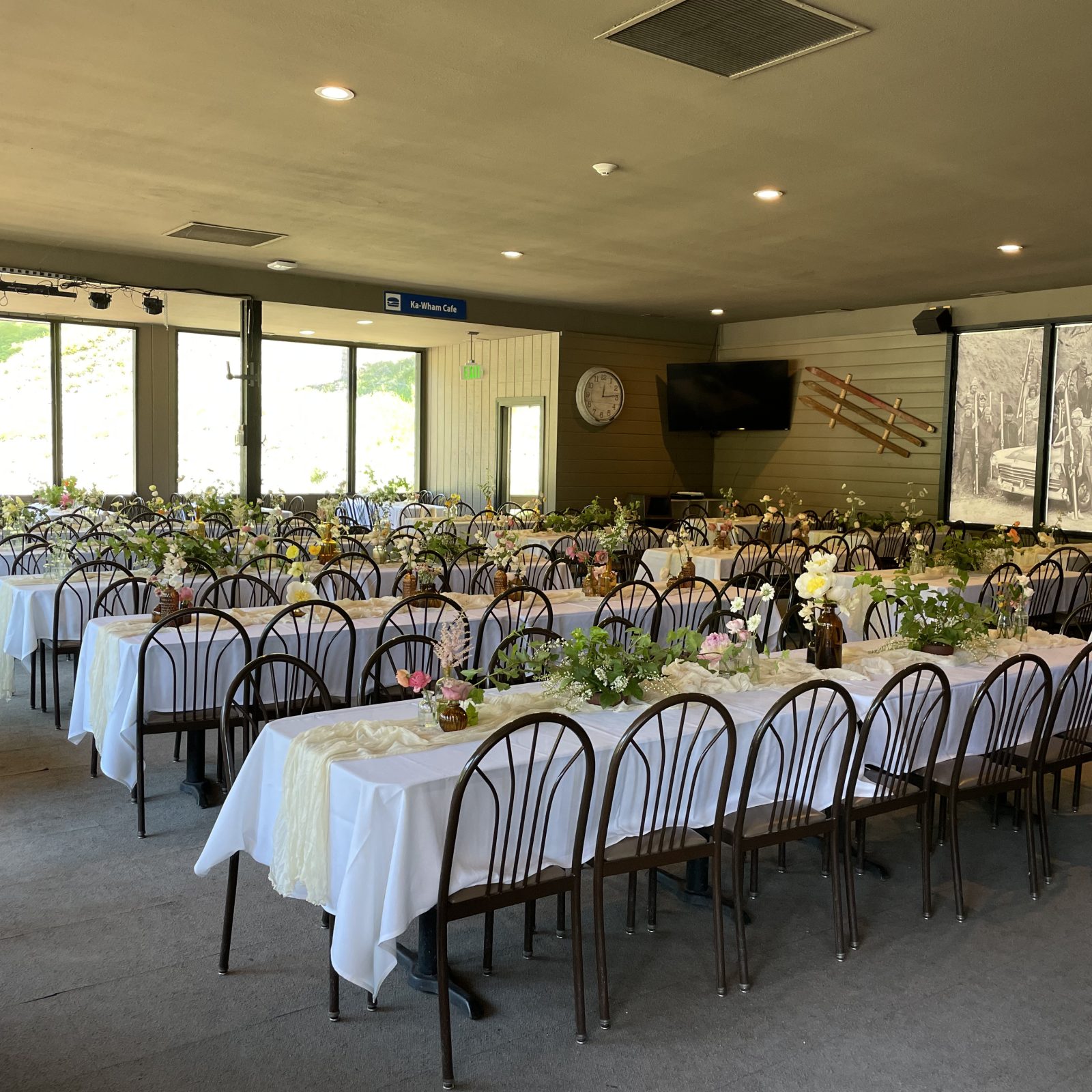 Tables set with white table cloths and flowers for a weeding reception inside the lodge