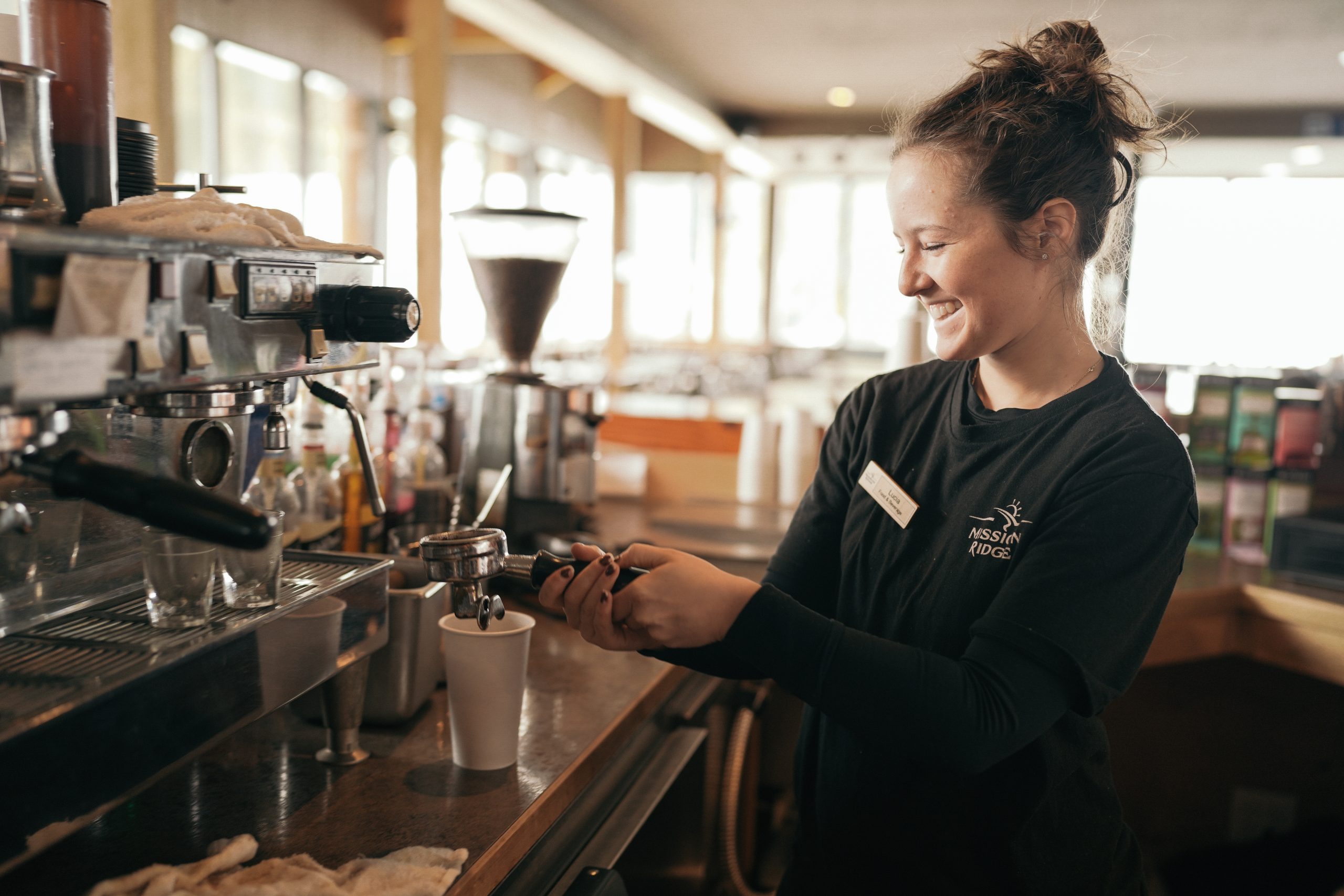 Barista smiling while pouring an espresso shot