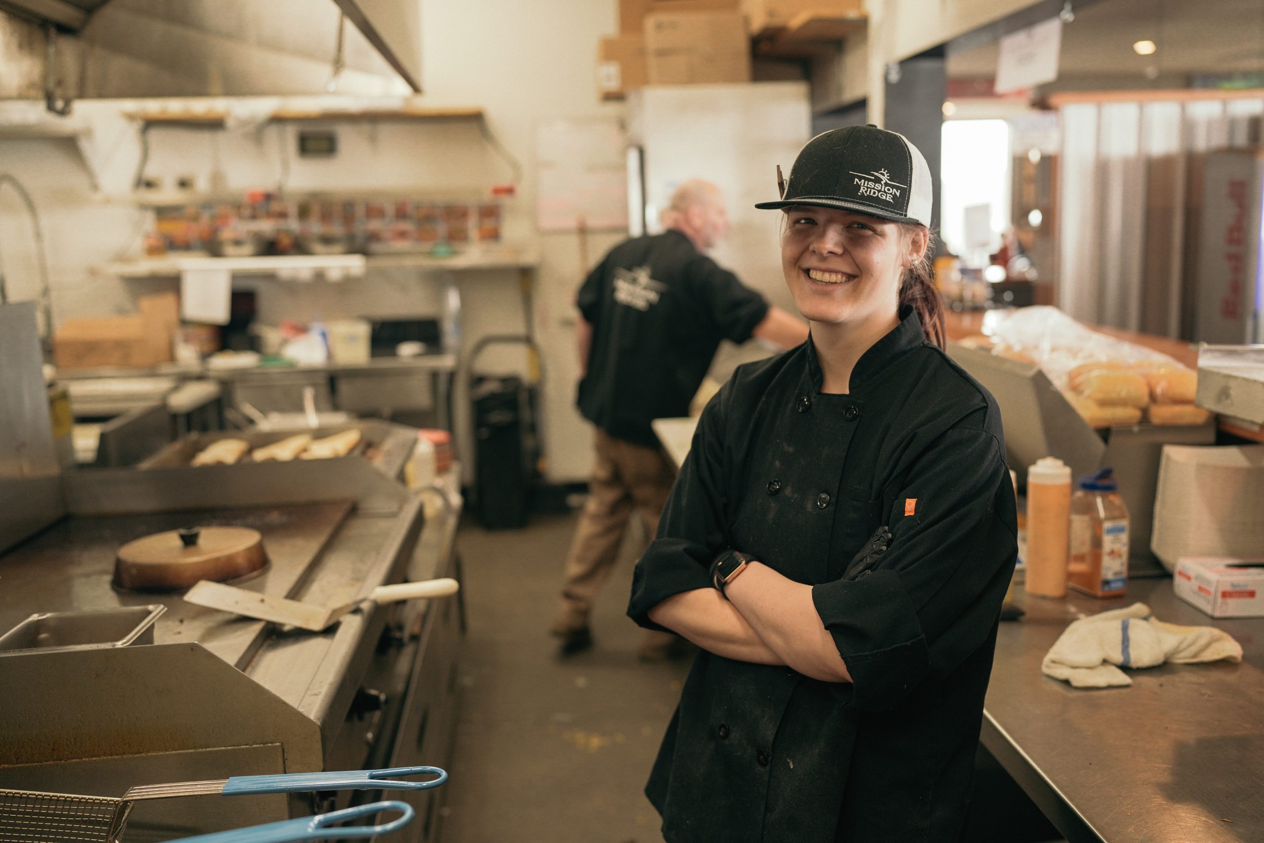 Cook smiling with arms crossed in the kitchen