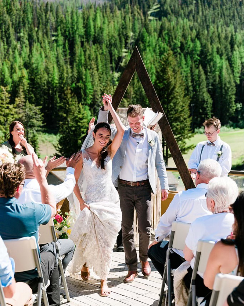 Newly wed couple celebrating after the wedding ceremony as they walk down the isle