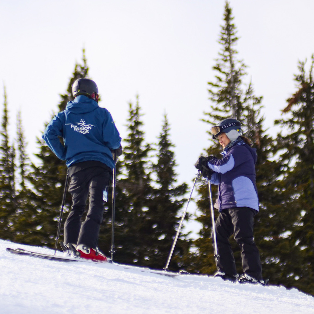 Ski instructor and skier discussing technique out on the slope