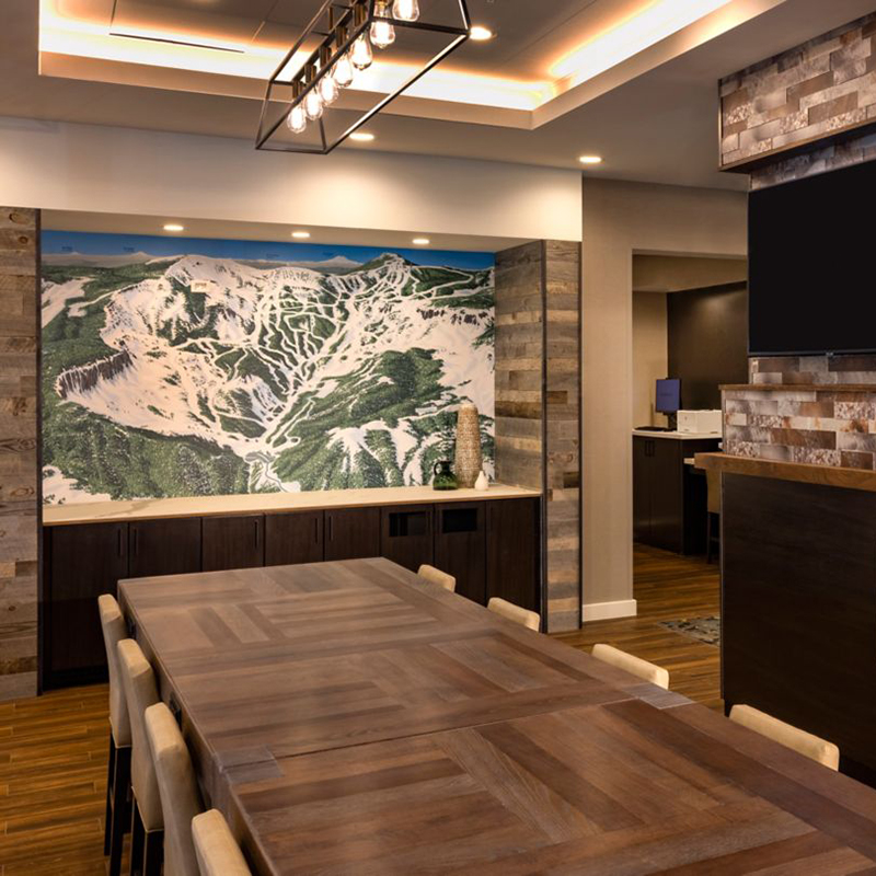 Hotel table with chairs in front of Mission Ridge map hanging on the wall.