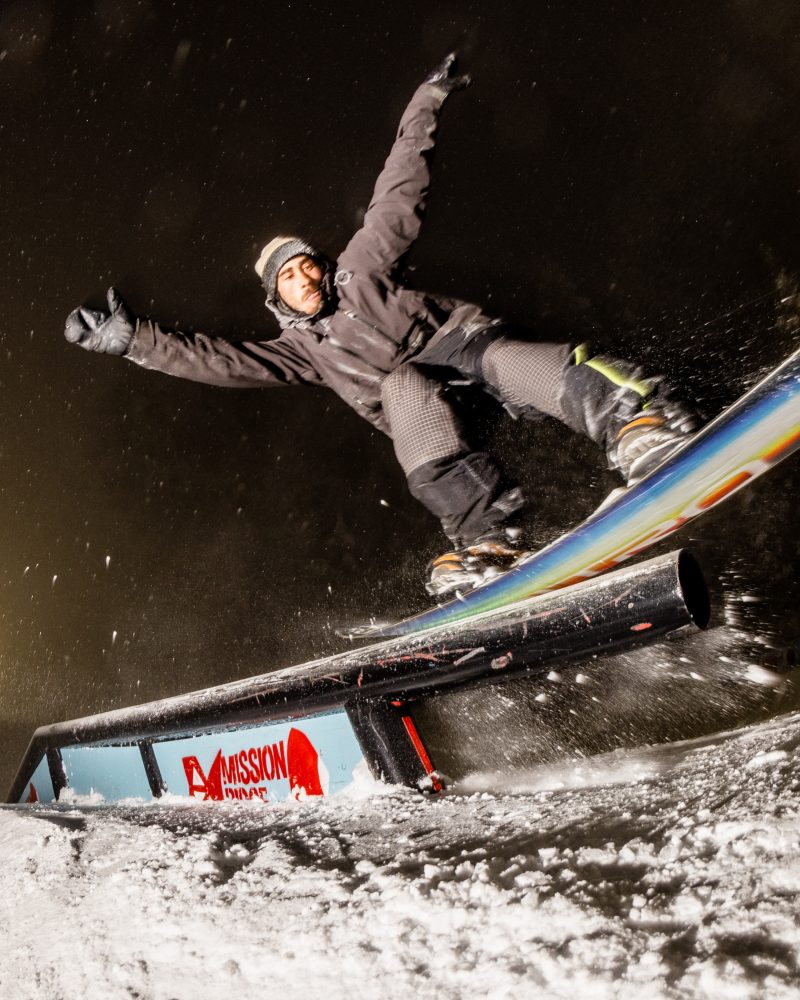 Snowboarder sliding rail in the 100LAPS Park during Night Skiing