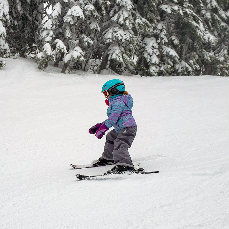 Young skier with no poles making turn on fresh snow