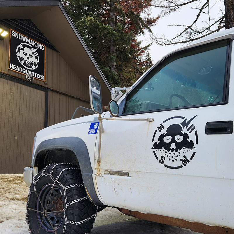 White truck with "MRSM" logo parked in front of Snowmaking Building at Mission Ridge