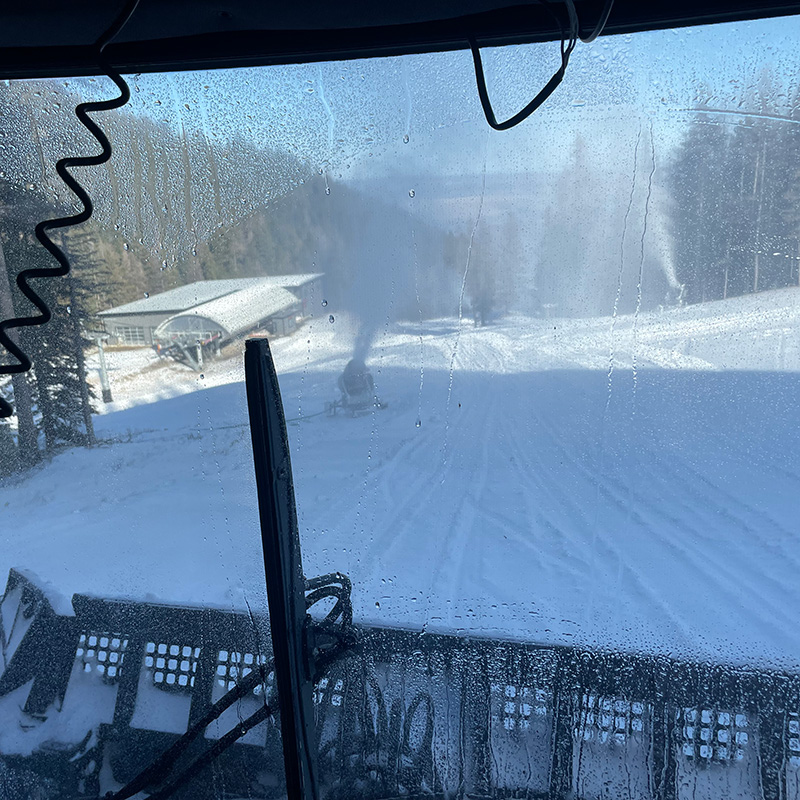 Snow guns making snow seen from the inside of a snowcat