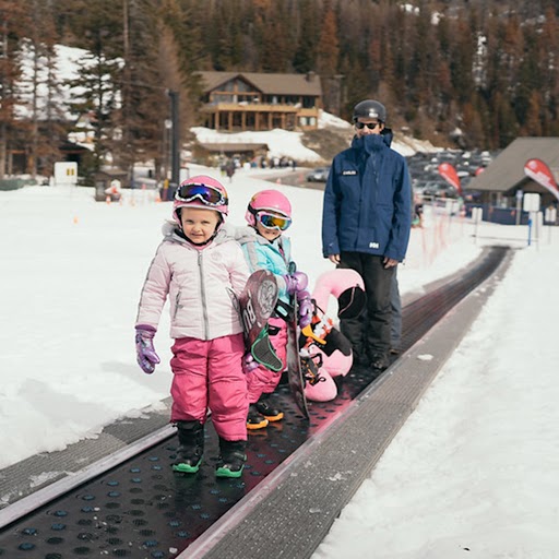 Children at Mission Ridge riding the magic carpet with ski gear