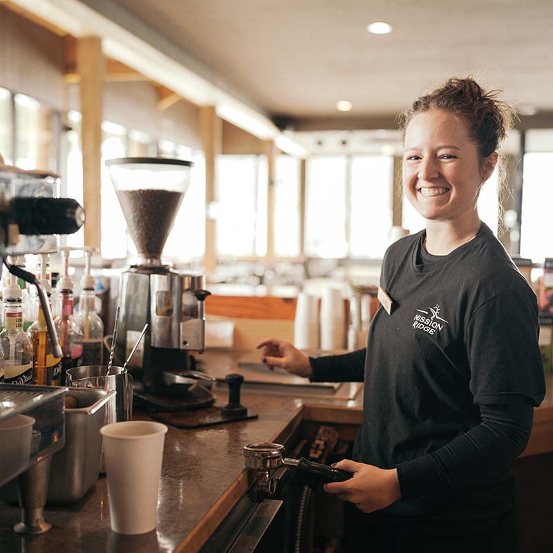 Mission Ridge barista smiling making an espresso shot.