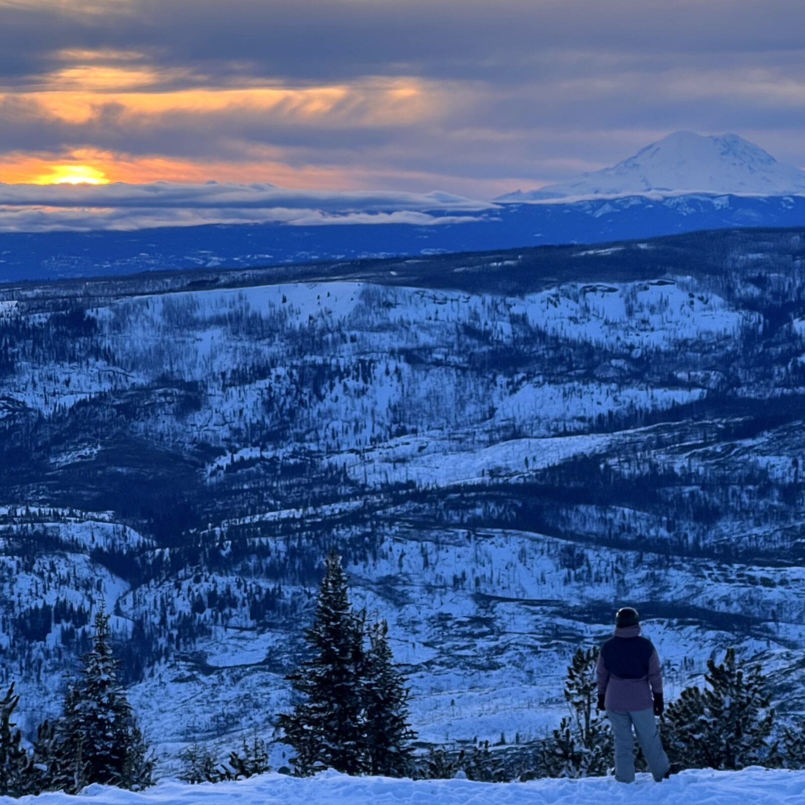 Skier viewing sunset from the summit of Mission RIdge