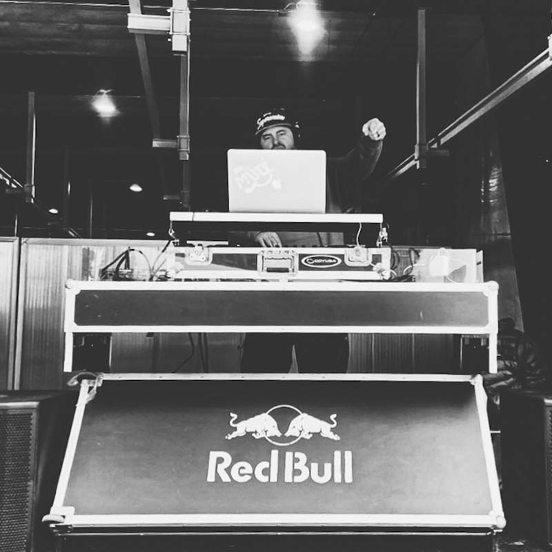 Black and white image of DJ Mabee behind DJ stand