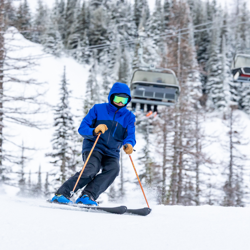 Blue jacket skier with bubble chair above
