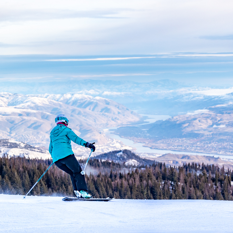 Skier from behind heading towards valley
