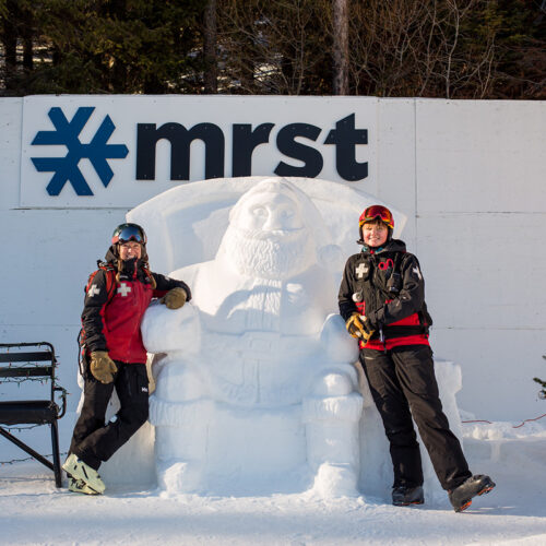 2 Patrollers posing with snow santa sculpture at Mission Ridge.