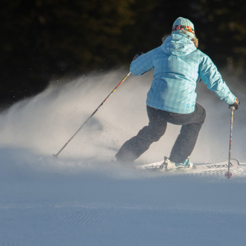 Skier in blue jacket on sunspot