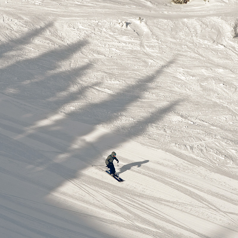 Skier from a distance making turn on fresh corduroy on the run Katsuk at Mission Ridge