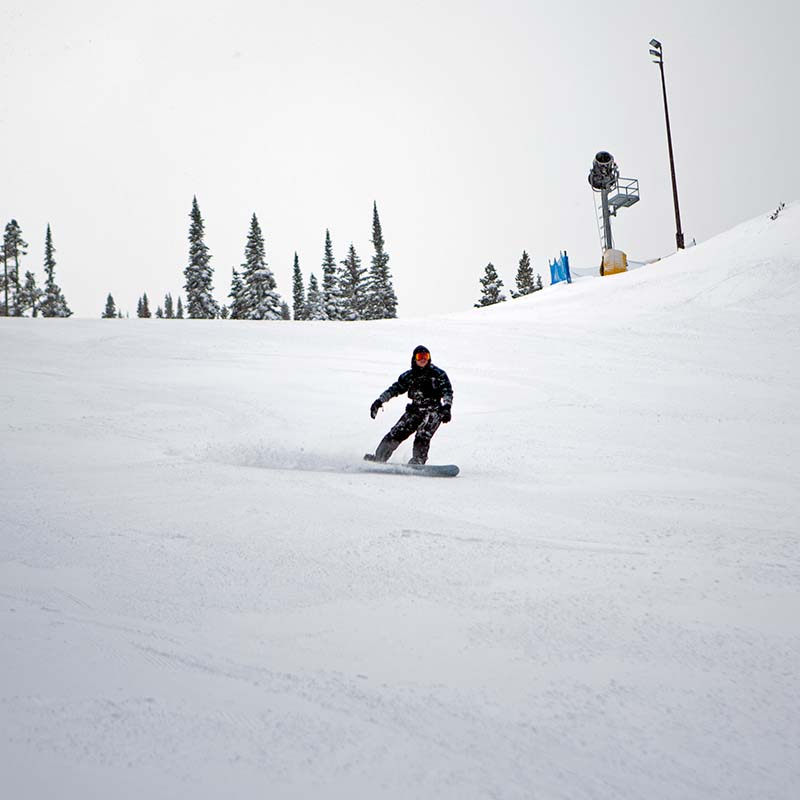 Snowboarder making turn on Tumwater run at Mission Ridge.