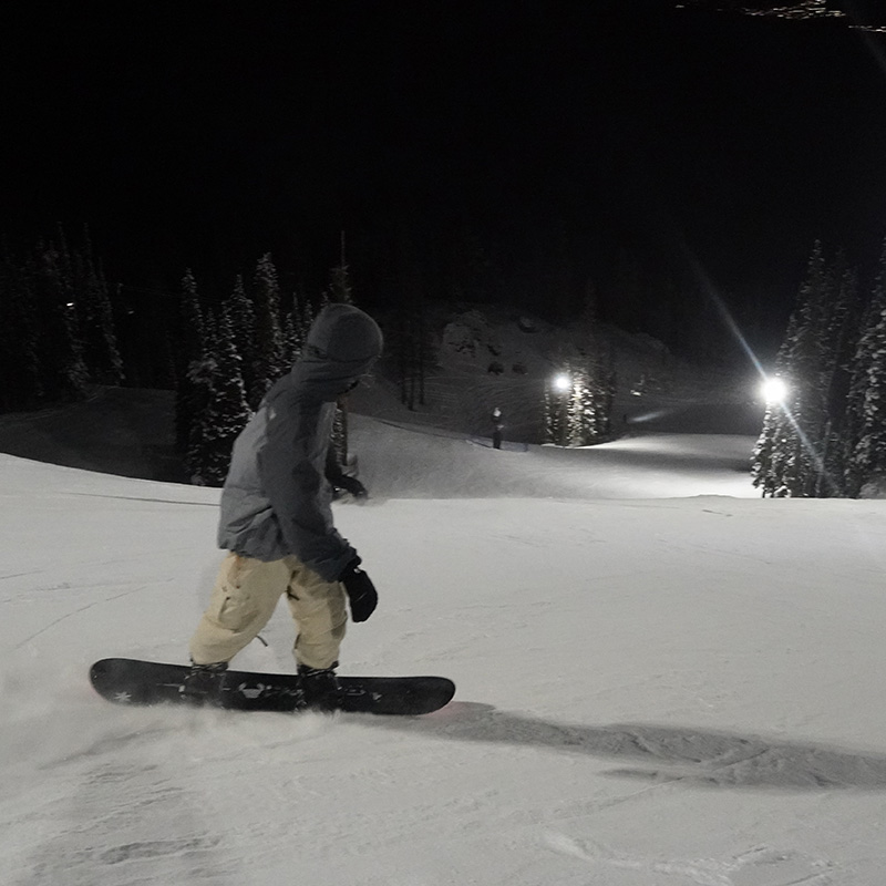 Snowboarder on Tumwater run at Mission Ridge at night.