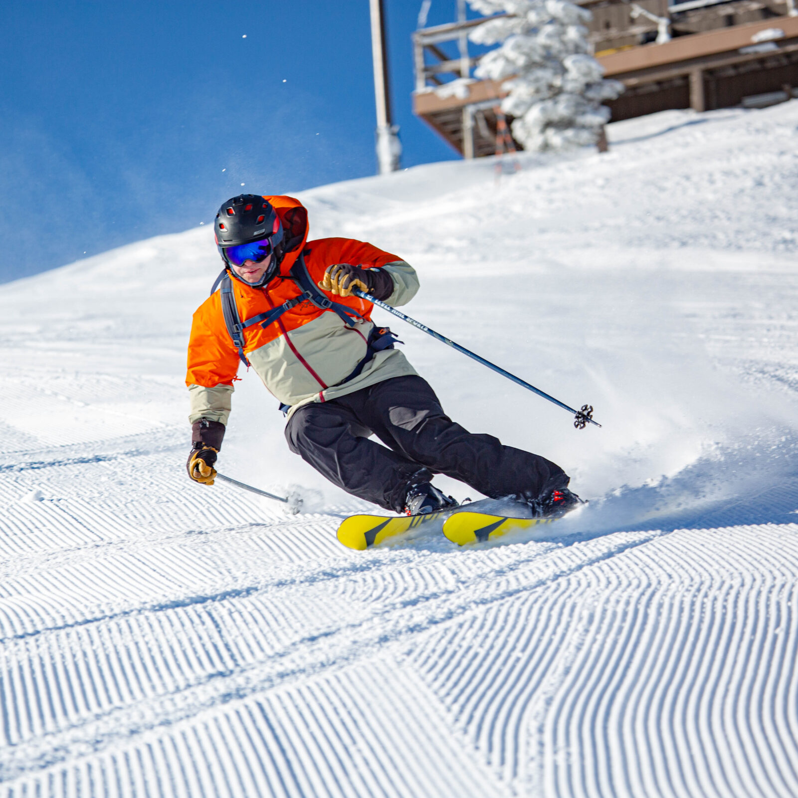 Skier carving under Ski Patrol top shack