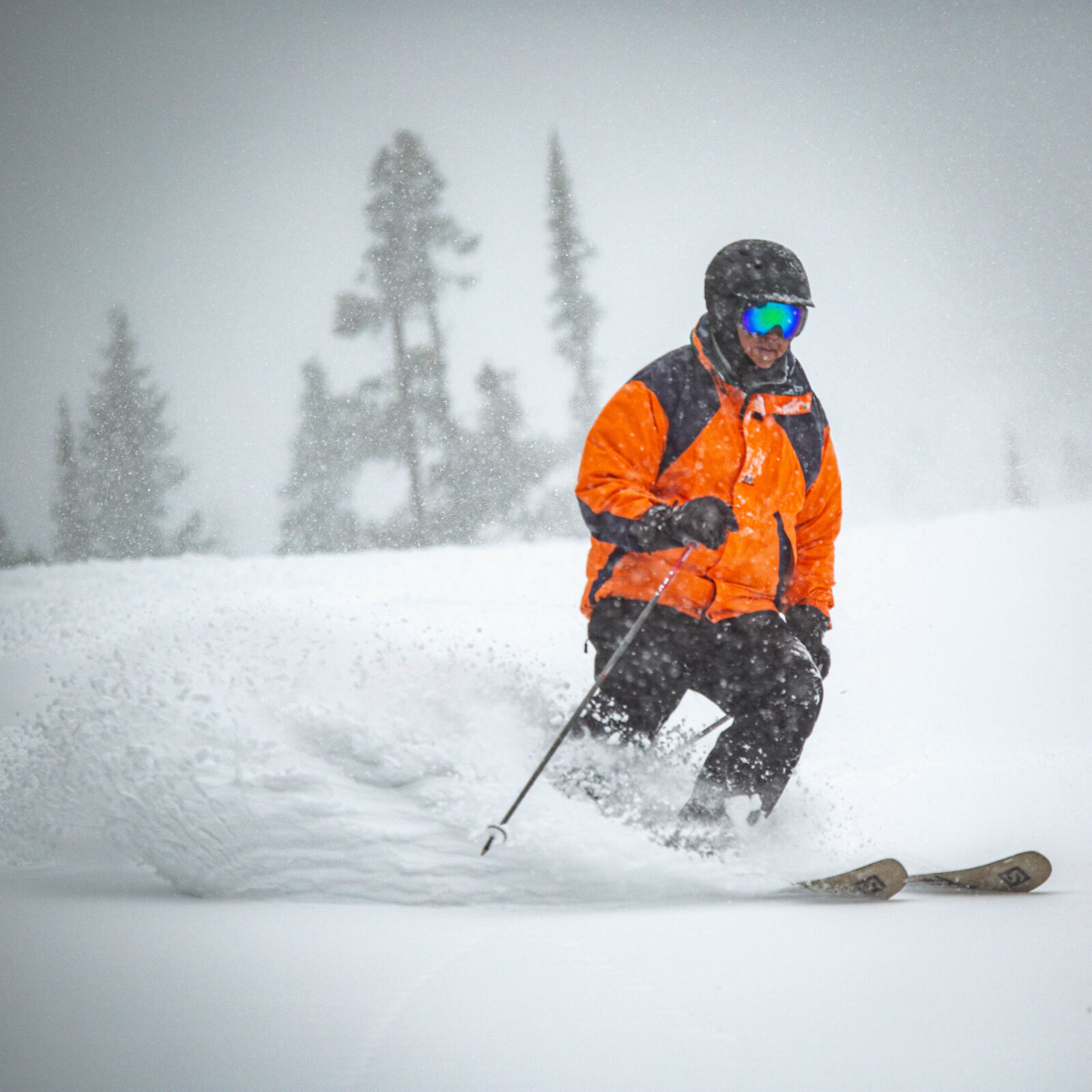 Skier in orange enjoying soft powder turns on Lower Tumwater