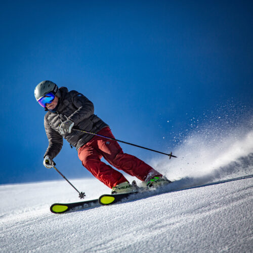 Skier carving in the sun on Sunspot