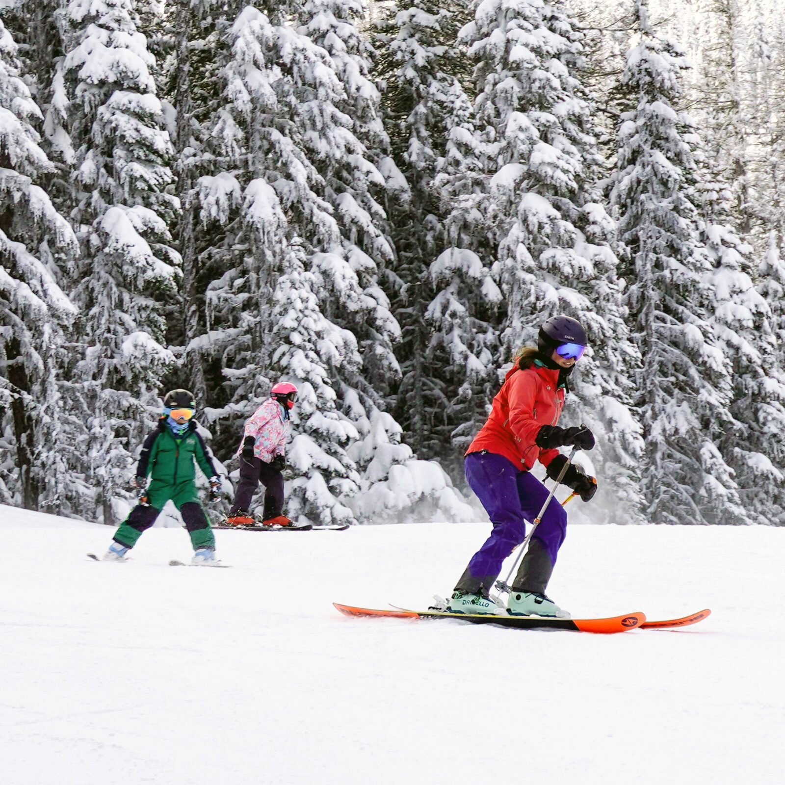 Skier family of three making turns together on the Tillikum run at Mission Ridge.