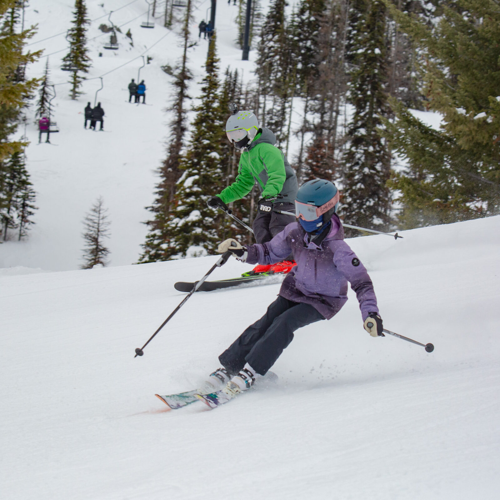 Two kids skiing on Castle, a run off of the Chair 4 lift. You can see chair 4 in the background.