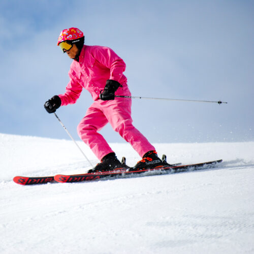 Skier in all pink outerwear goes down sunspot off of Chair 2 at Mission Ridge during Flamingo Days event.