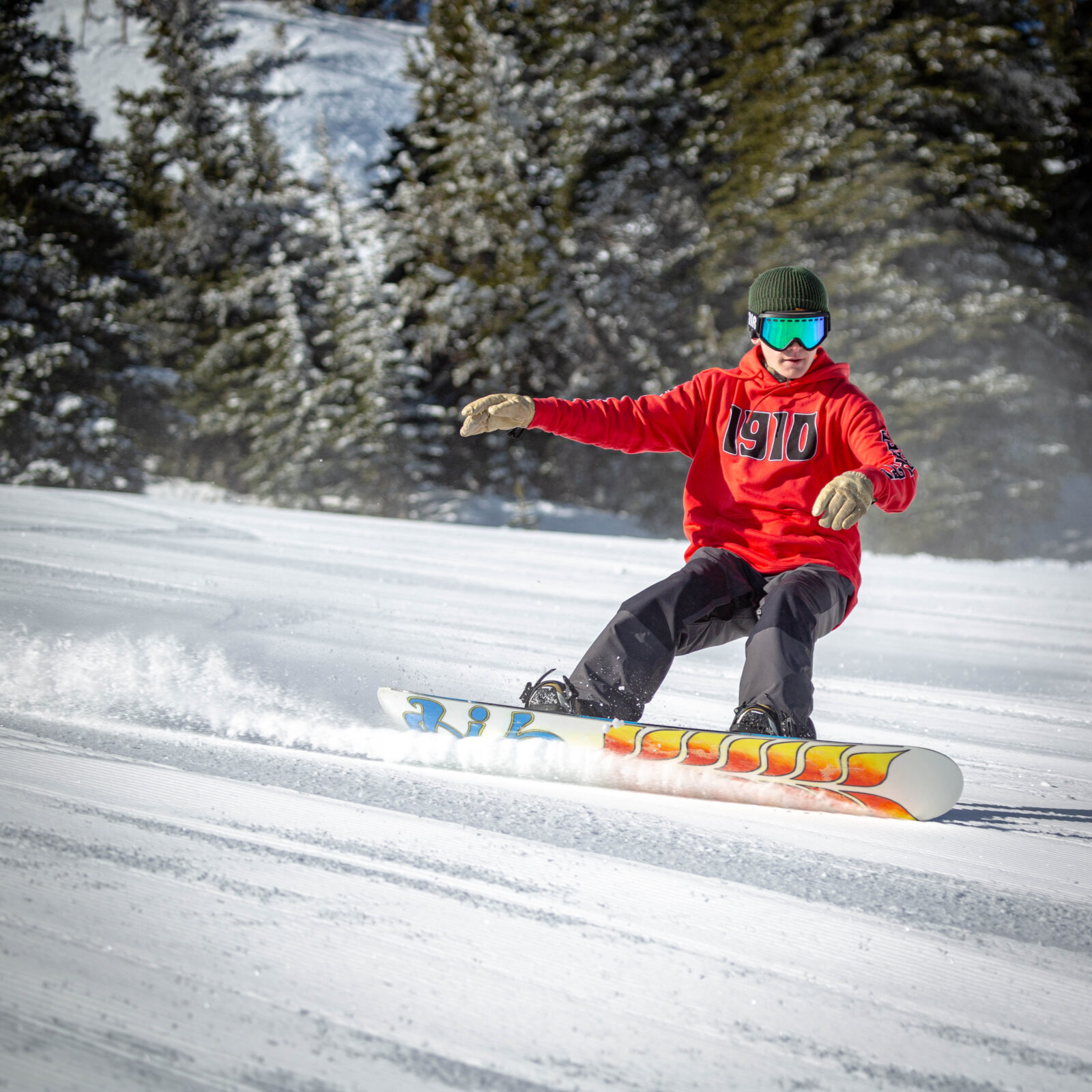 Snowboarder in red and black carving on Sun Spot