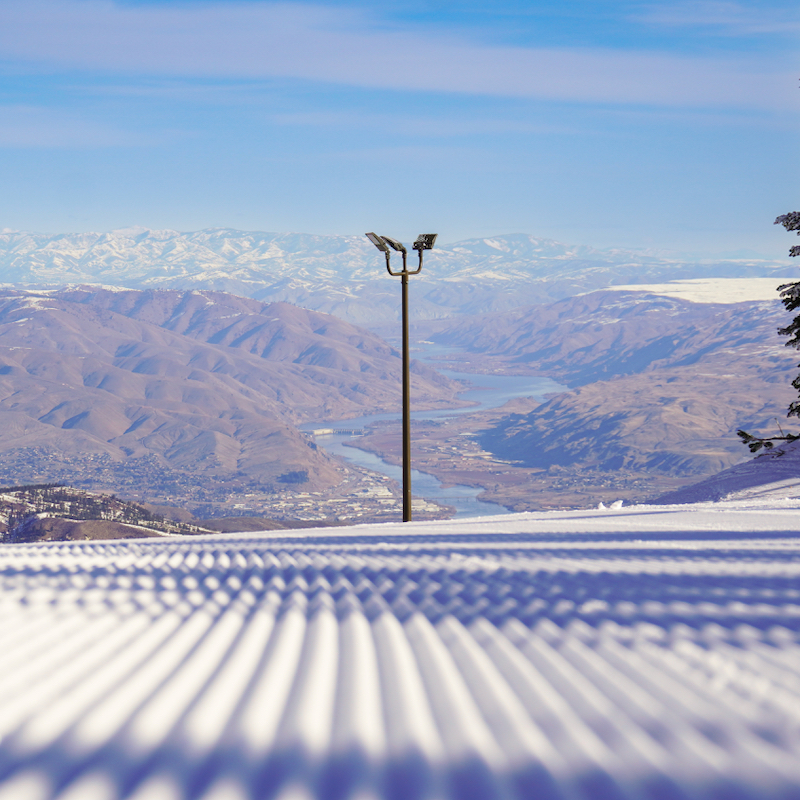 Fresh corduroy on the Sunspot Trail at Mission ridge, with a valley view in the background including the Columbia River.
