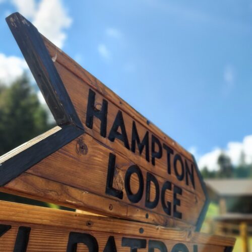 A wooden sign with the text "Hampton Lodge"