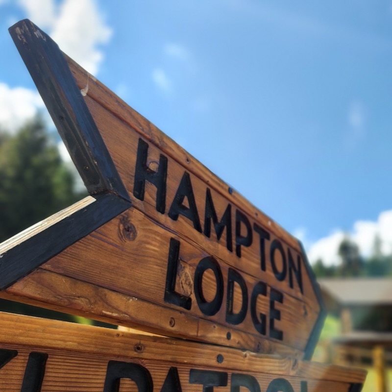 A wooden sign with the text "Hampton Lodge"
