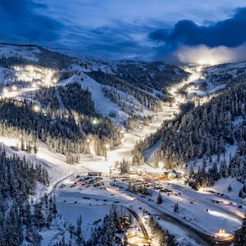 An aerial view of Mission Ridge in the evening with the night skiing lights on.