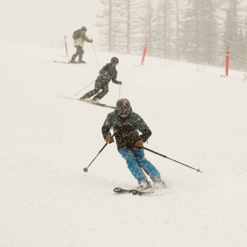 Skiers descend the Tumwater trail at Mission Ridge on a snowy day