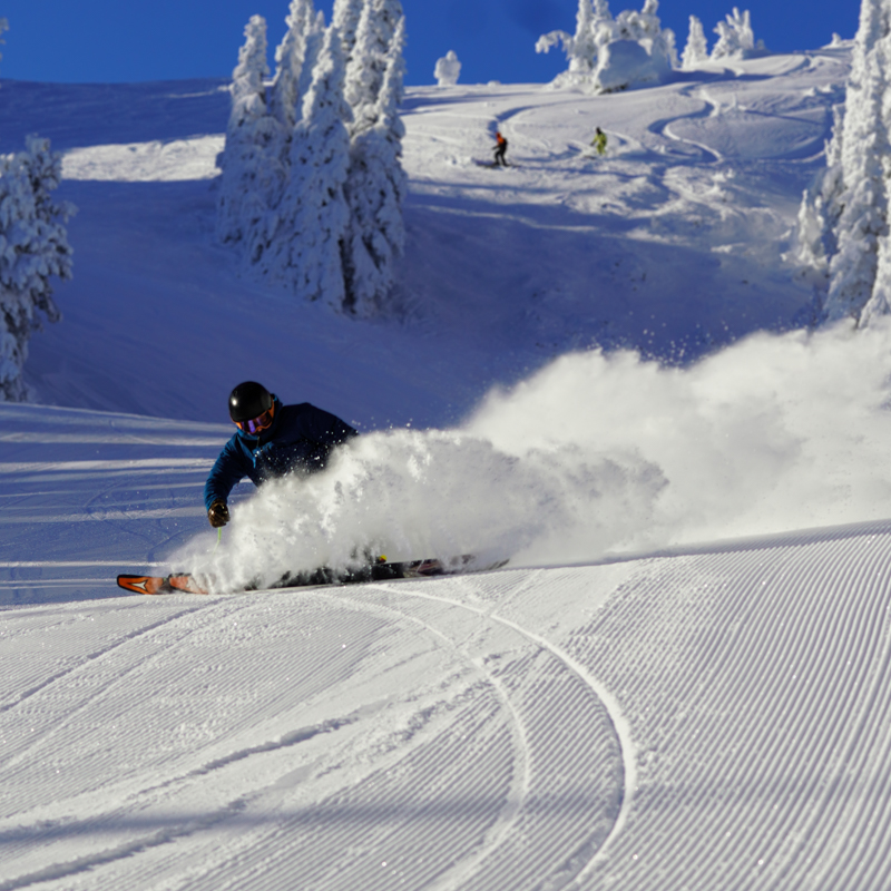 A skier slashes up snow on a groomed run at Mission Ridge.