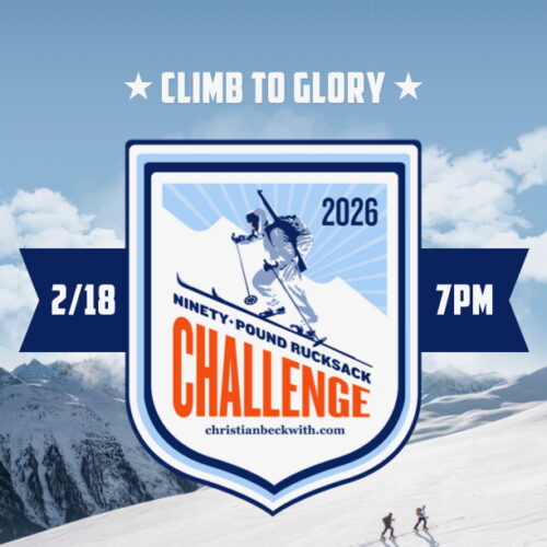 Participant hiking uphill carrying a ninety-pound rucksack as part of the 90-Pound Rucksack Challenge.