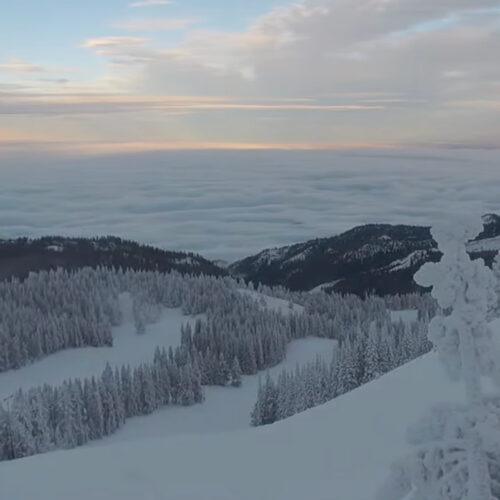 A view from the top of Mission Ridge of a snowy mountainside above a sea of clouds.