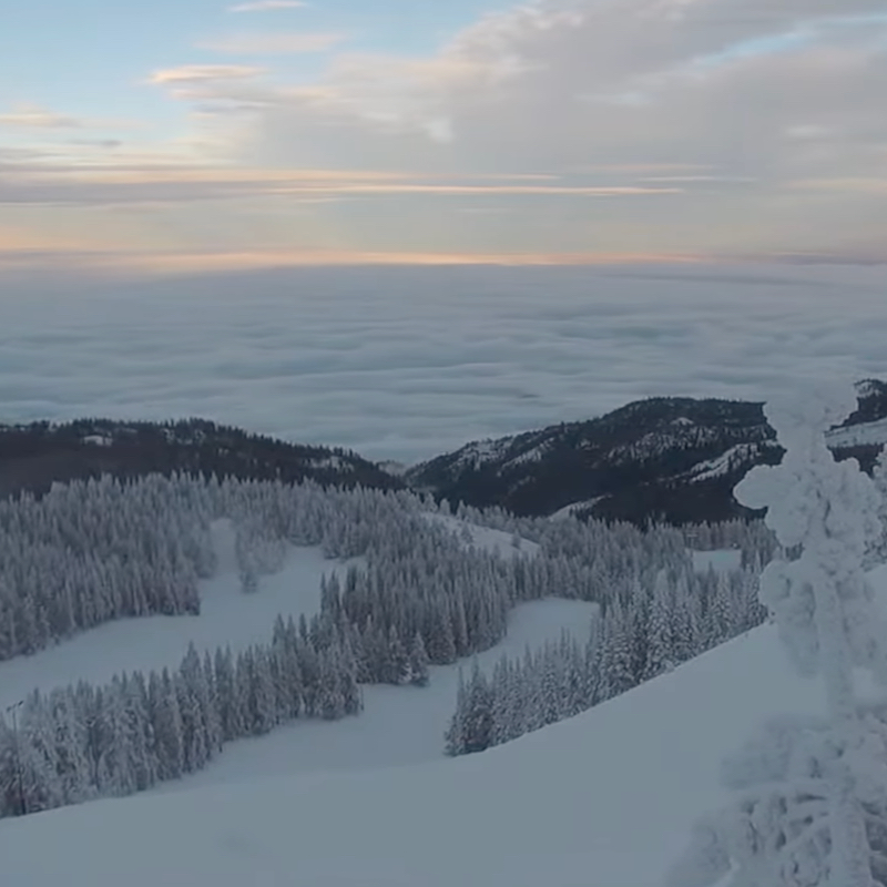 A view from the top of Mission Ridge of a snowy mountainside above a sea of clouds.