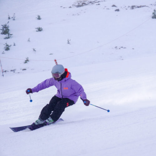 a woman rips down a slope on skis
