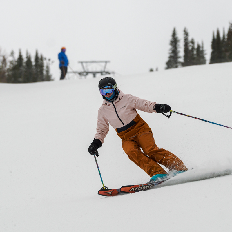 a skier in pink descends an overcast slope