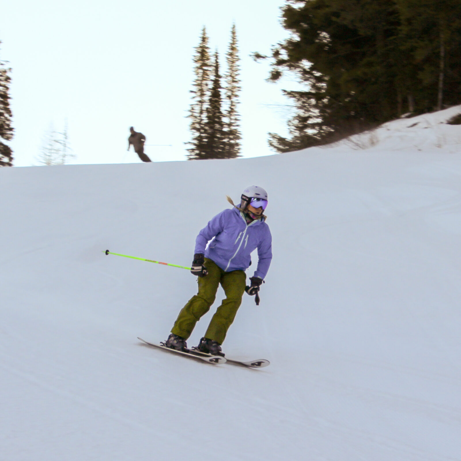 a woman skies down a shady slope