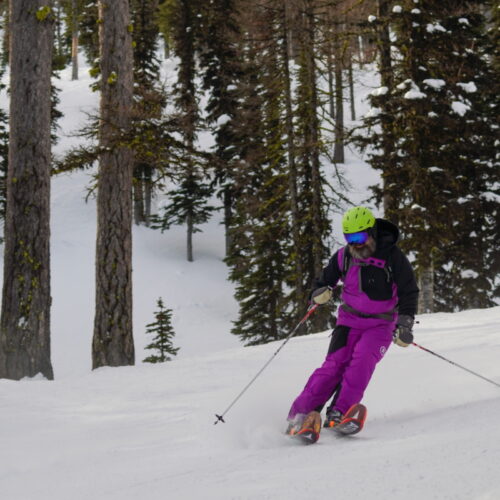 Purple skier dude sliding on snow