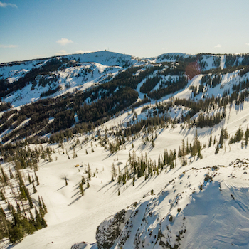 Aerial view of Mission Ridge ski area on a sunny day with snow on the ground.