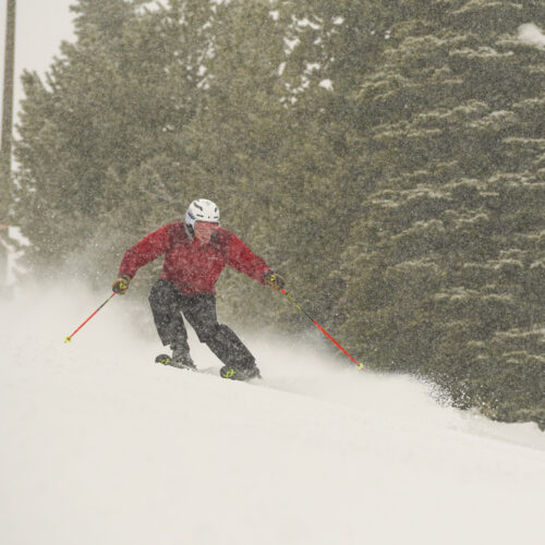 A skier descends the Sunspot Trail at Mission ridge on a snowy day.