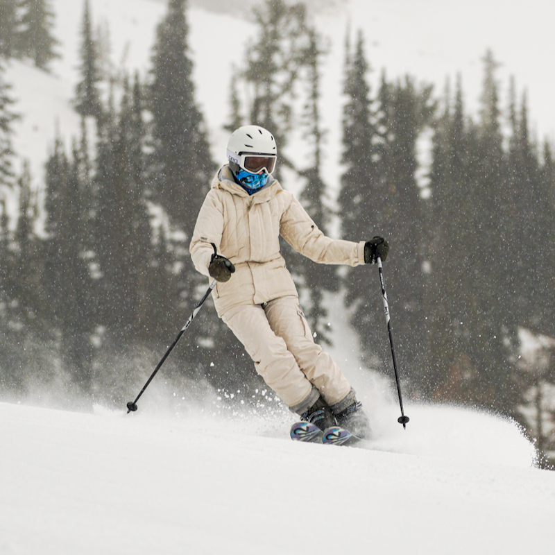 A skier descends the Tumwater trail at Mission Ridge with flurries in the air behind her.
