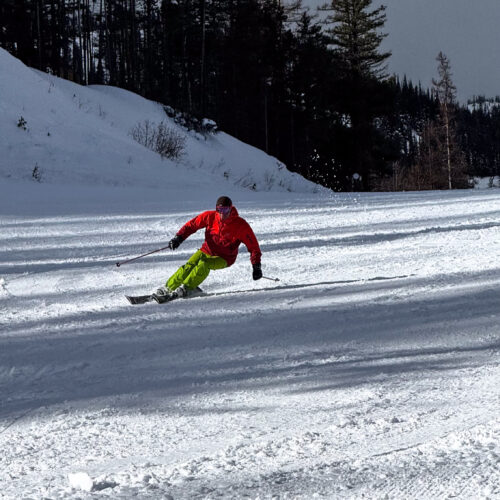 Skier carving a turn on freshly groomed snow at Mission Ridge Ski & Board Resort near Wenatchee, Washington.