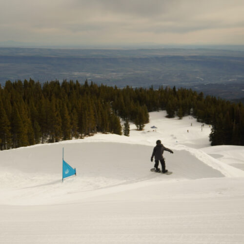 A snowboarder descends the banked slalom course at mission Ridge.