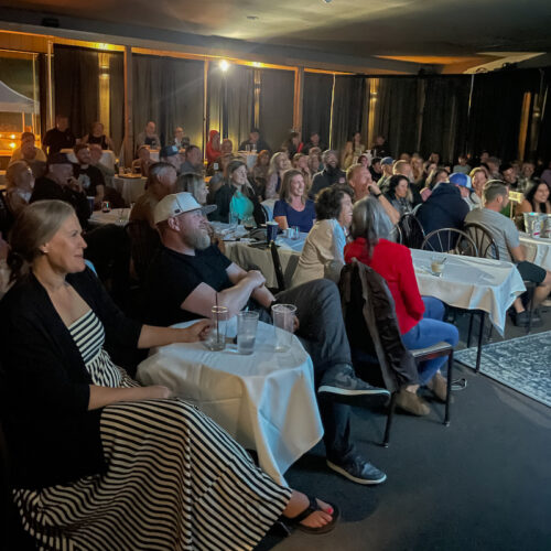 A crowd watches a comedy show at the Hampton Lodge.
