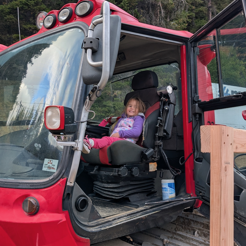 A child sitting in the cab of a Mission Ridge snowcat